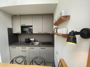 uma pequena cozinha com armários brancos e uma mesa em Puur Mechelen em Mechelen