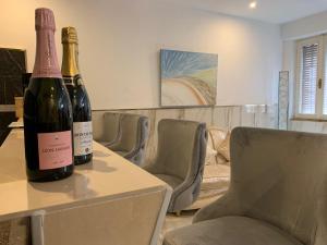 dos botellas de vino sentadas en una mesa con sillas en bristol palace en Rodigo
