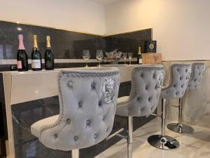 un bar con 2 sillas y botellas de vino en bristol palace en Rodigo