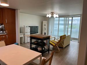 a kitchen and living room with a table and chairs at Sam Apartment in Goyang