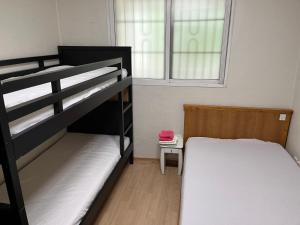 a bedroom with two bunk beds and a window at Sam Apartment in Goyang