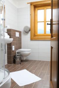 łazienka z toaletą, umywalką i oknem w obiekcie Koliba Hubertka w mieście Oravice