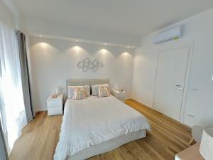 - une chambre blanche avec un grand lit et 2 oreillers dans l'établissement Maison BP - A 2 minuti dalla Stazione Ferroviaria, à Prato
