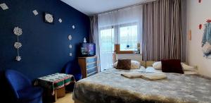 1 dormitorio con cama y pared azul en Szymusiowa Szczyrk, en Szczyrk