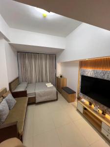 Cette grande chambre comprend un lit et une télévision à écran plat. dans l'établissement Studio Unit located at 38 Park Avenue Condominium in IT Park Cebu, à Cebu