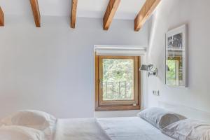 a bedroom with two beds and a window at Desbrull in Pollença