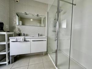 y baño blanco con lavabo y ducha. en Le Sublime- Vue climatisation et parking ! en Montpellier