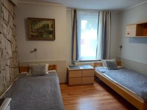 Habitación con 2 camas y ventana en Villa Laura, en Polanica-Zdrój