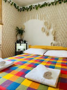 Naryn的住宿－Dadow Cozy House，一间卧室配有一张色彩缤纷的床和毛巾