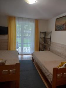 ポラニツァ・ズドルイにあるVilla Lauraのベッド2台と窓が備わるホテルルームです。
