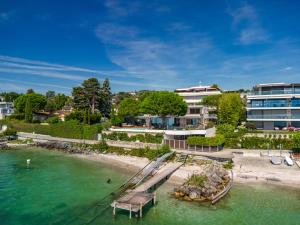 een luchtzicht op een strand met een resort bij Lausanne area Luxurious 4-Bedroom Villa on the Lake by GuestLee in Pully