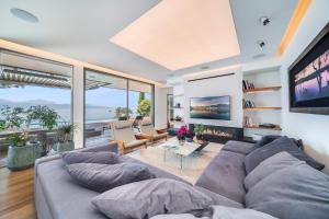 un soggiorno con divano grigio e TV di Lausanne area Luxurious 4-Bedroom Villa on the Lake by GuestLee a Pully