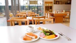 近江八幡的住宿－近江八幡ステーションホテル，餐桌,带两盘食物和一杯咖啡的桌子