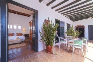 サン・バルトロメにあるCaserio de Mozagaのベッド、テーブル、椅子が備わる客室です。