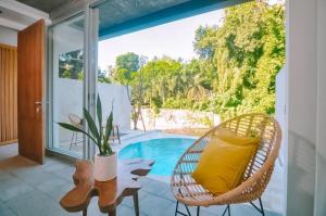 a room with a chair and a table and a pool at Loji Nyanyi in Tanah Lot