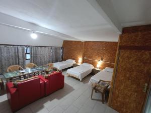 Cette chambre d'hôtel comprend deux lits, une table et des chaises. dans l'établissement Guesthouse Eva Duplex Apartment, à Berat