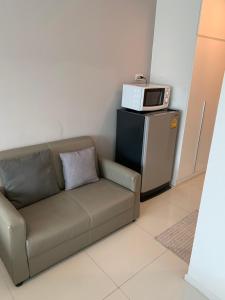 ein Sofa mit einer Mikrowelle auf dem Kühlschrank in der Unterkunft 2 mins walk to BTS Bang Chak in Bangkok