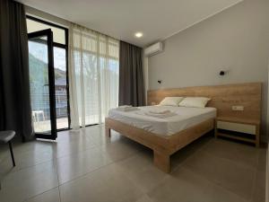 una camera da letto con un letto e una grande finestra di Best place in gonio a Gonio