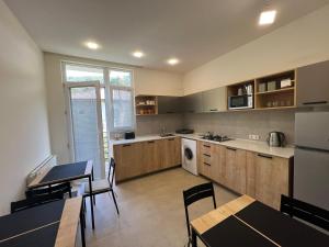 una cucina con mobili in legno, tavolo e sedie di Best place in gonio a Gonio