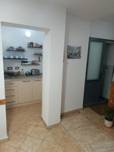 a kitchen with white walls and a white pillar at Guesthouse Eva Duplex Apartment in Berat