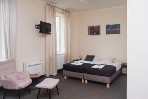 ein Hotelzimmer mit einem Bett und einem Stuhl in der Unterkunft Zielone Podlasie Zakład Aktywności Zawodowej in Ruda
