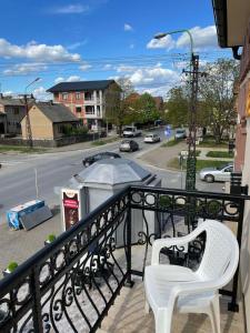 a white chair sitting on a balcony with a street at Sobe Sara in Šabac