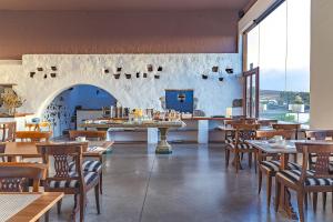 サン・バルトロメにあるCaserio de Mozagaの木製のテーブルと椅子、大きな窓が備わるレストラン