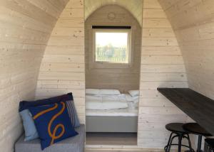 HarboørにあるCamping Vesterhavのベッドと窓が備わる小さな客室です。