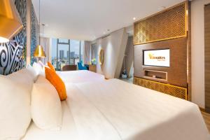 a hotel room with two beds and a television at Winsuites Saigon in Ho Chi Minh City
