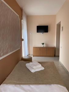 a hotel room with a bed and a flat screen tv at Sobe Sara in Šabac