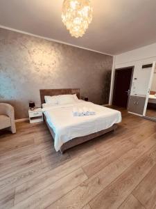 sypialnia z białym łóżkiem i żyrandolem w obiekcie The Chalet w mieście Năvodari