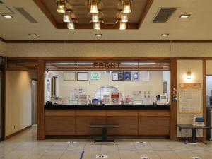 un hall avec un comptoir dans un bâtiment dans l'établissement Unohama Onsen Royal Hotel Kobayashi, à Joetsu