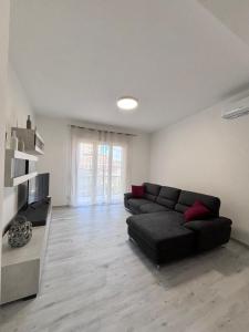 sala de estar con sofá negro y ventana en Grey House, en Arezzo
