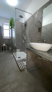 een badkamer met een witte wastafel en een douche bij SuiteSicily Rooms Vasca Idromassaggio Palermo in Altavilla Milicia