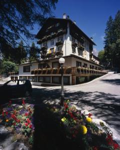 ein großes Gebäude mit Blumen davor in der Unterkunft Hotel Majoni in Cortina d'Ampezzo