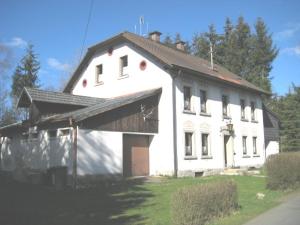 a large white building with a gambrel roof at Zigeunermühle in Weißenstadt