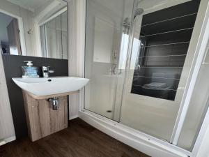 ein Bad mit einem Waschbecken und einer Dusche in der Unterkunft Lovely 2-Bed Caravan in Prestonpans in Longniddry