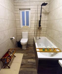 a bathroom with a bath tub and a toilet at Central 2BR Apartment with Balcony by Apricus Design in Msida