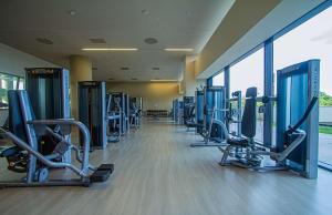 a gym with a row of treadms and machines at Grand Hotel Djibloho in Djibloho