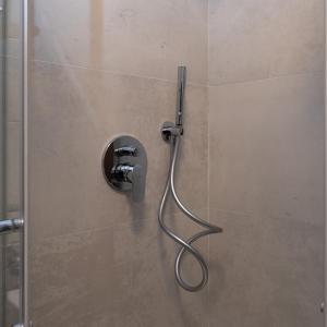a shower with a hose attached to a wall at Bilocale a Lainate LainHouse in Lainate