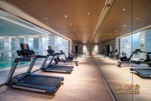 a gym with a row of treadmills in a building at L+Snow Supreme Hotel in Shanghai