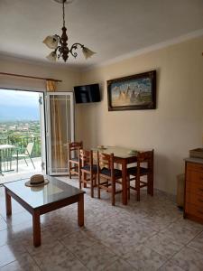 a living room with a table and chairs and a view at Kallithea Studios & Apts in Lakíthra