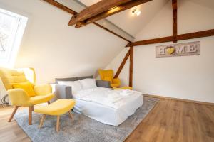 - une chambre avec un lit et des chaises jaunes dans l'établissement IBM I Bertrandt I Küche I 6 Per., à Ehningen