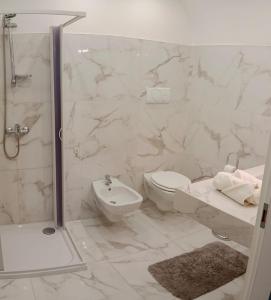 y baño blanco con aseo y ducha. en Casa Vacanza Altamura en Altamura