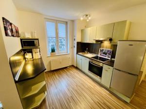 uma cozinha com um frigorífico em aço inoxidável e pisos em madeira em Charlotte, direkt am Kurpark em Warnemünde