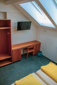 Zimmer mit einem Schreibtisch und einem TV an der Wand in der Unterkunft Robbesscheier in Munshausen