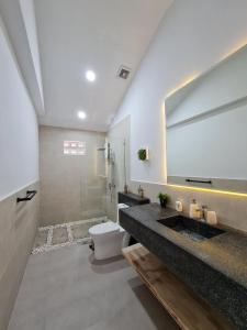 a bathroom with a sink and a toilet and a mirror at Private Villa in Phumĭ Prêk Chrey