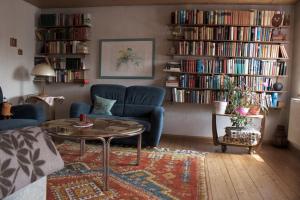 ein Wohnzimmer mit einem Sofa, einem Tisch und Büchern in der Unterkunft Schwabenhof Ferienwohnung II in Leutershausen