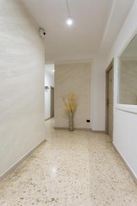 a hallway with white walls and a vase of flowers at Napoli Fly Guest House 290 in Naples