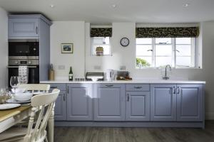 a kitchen with blue cabinets and a table at Crows Hall in Colchester